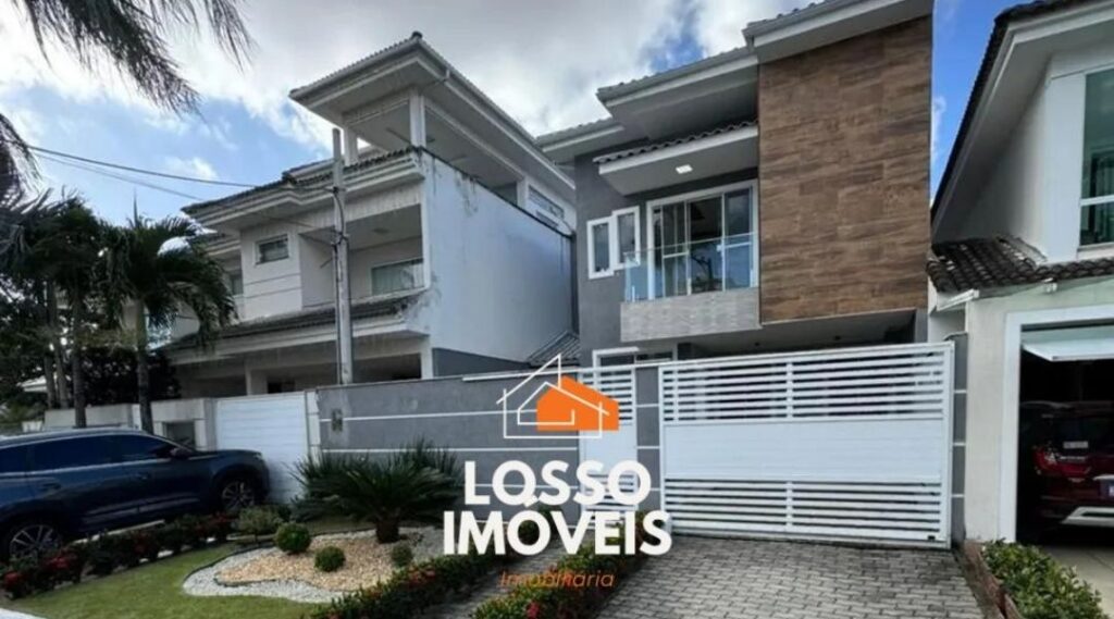 casa moderna de dois andares com portão branco, jardim, carro na garagem e logo Losso Imóveis