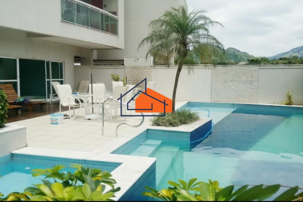 Área externa com piscina, palmeira central, mesa com cadeiras e montanhas ao fundo.